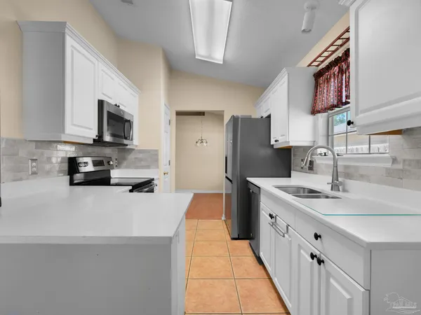 a kitchen with stainless steel appliances a sink stove refrigerator and a cabinets