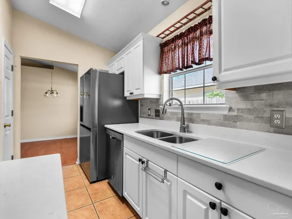 a kitchen with stainless steel appliances granite countertop a sink and a refrigerator