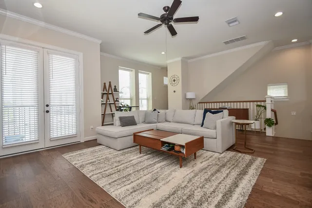 a living room with furniture and a wooden floor