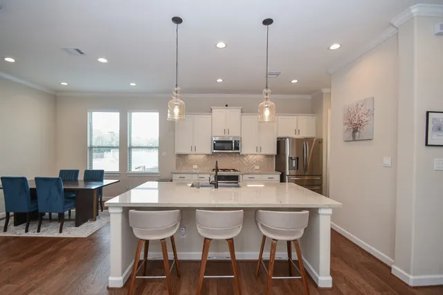 a kitchen with stainless steel appliances kitchen island a sink stove and refrigerator