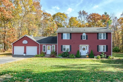 a front view of a house with a yard and trees