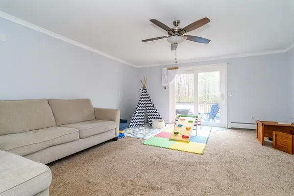 a living room with furniture and a ceiling fan