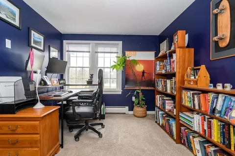 a view of a workspace with furniture and a bookshelf