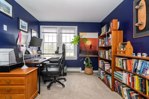 a view of a workspace with furniture and a bookshelf