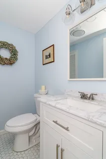 a bathroom with a granite countertop toilet sink and mirror