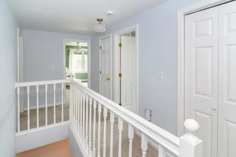 a view of a hallway with wooden floor and windows