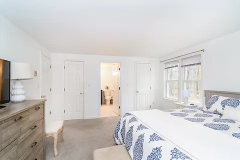 a spacious bedroom with a bed and a flat screen tv