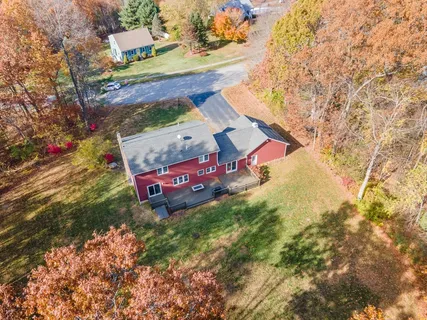 an aerial view of residential house with outdoor space and trees all around