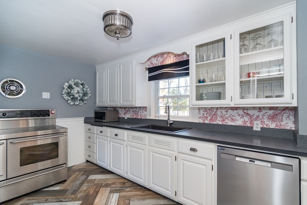 399 Edgell Road Framingham, MA 01701 - Photo 4 of 24 a kitchen with granite countertop a sink stainless steel appliances and cabinets