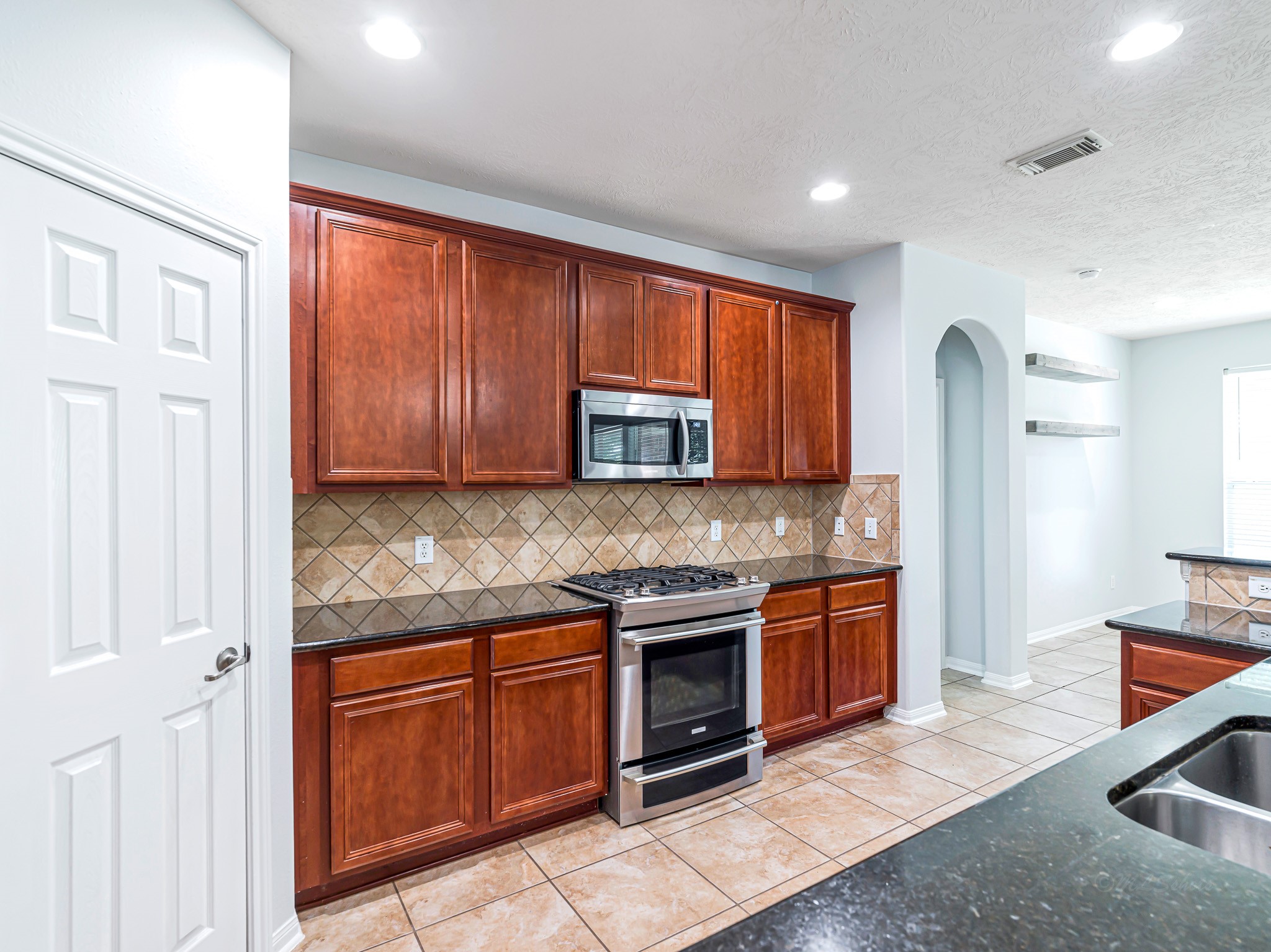 25203 Auburn Terrace Drive Spring, TX 77389 - Photo 7 of 21 a kitchen with stainless steel appliances granite countertop a stove top oven a sink and dishwasher