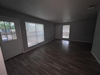 5011 Copperbend Boulevard, Unit B Austin, TX 78744 - Photo 4 of 10 an empty room with wooden floor and windows