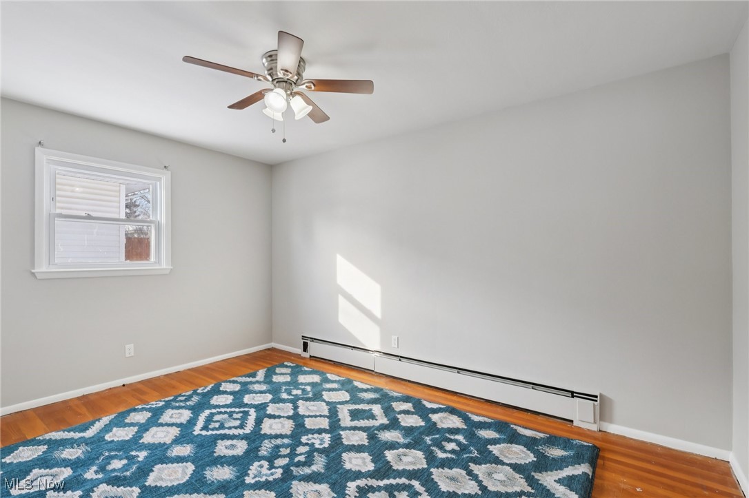 611 Wilson Street Struthers, OH 44471 - Photo 27 of 44 Spare room with a baseboard radiator, wood finished floors, and a ceiling fan