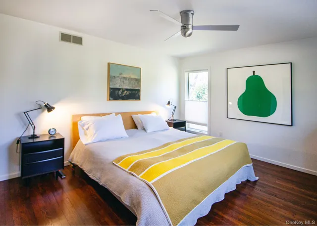 a bedroom with a bed and a painting on the wall