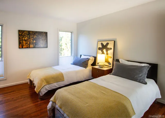 a bedroom with two beds and wooden floor