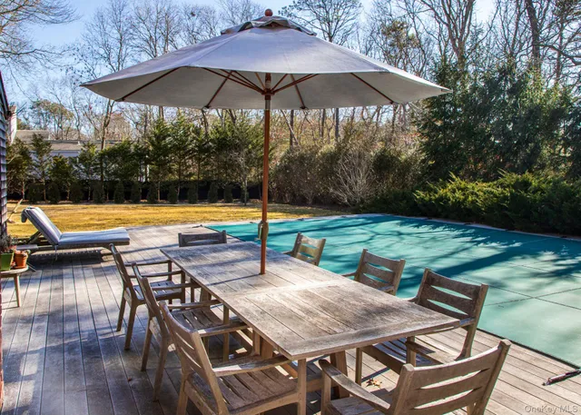 a view of a patio with table and chairs under an umbrella