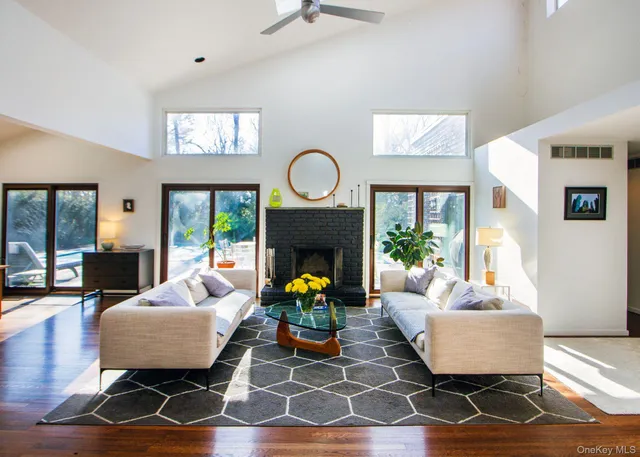 a living room with furniture a fireplace and a large window
