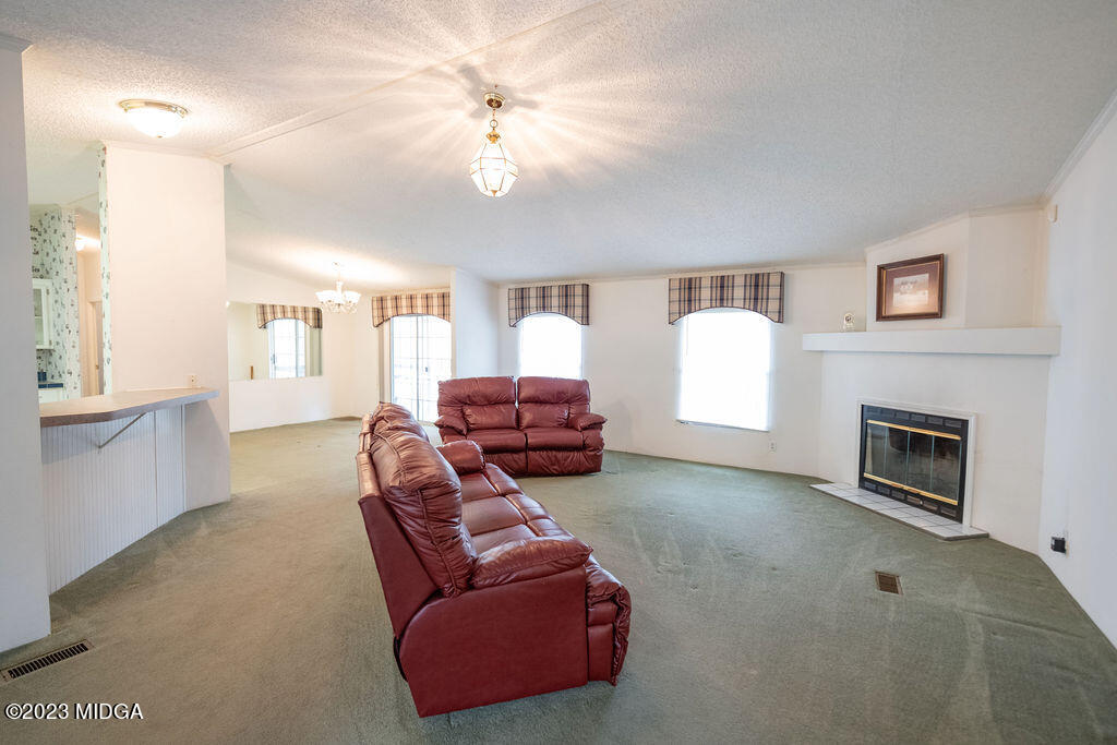5933 Moseley Dixon Road Macon, GA 31220 - Photo 6 of 38 a living room with furniture a fireplace and a flat screen tv
