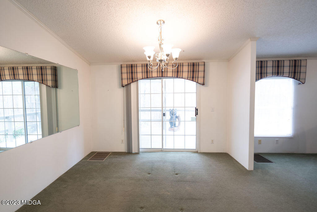 5933 Moseley Dixon Road Macon, GA 31220 - Photo 8 of 38 an empty room with windows and chandelier