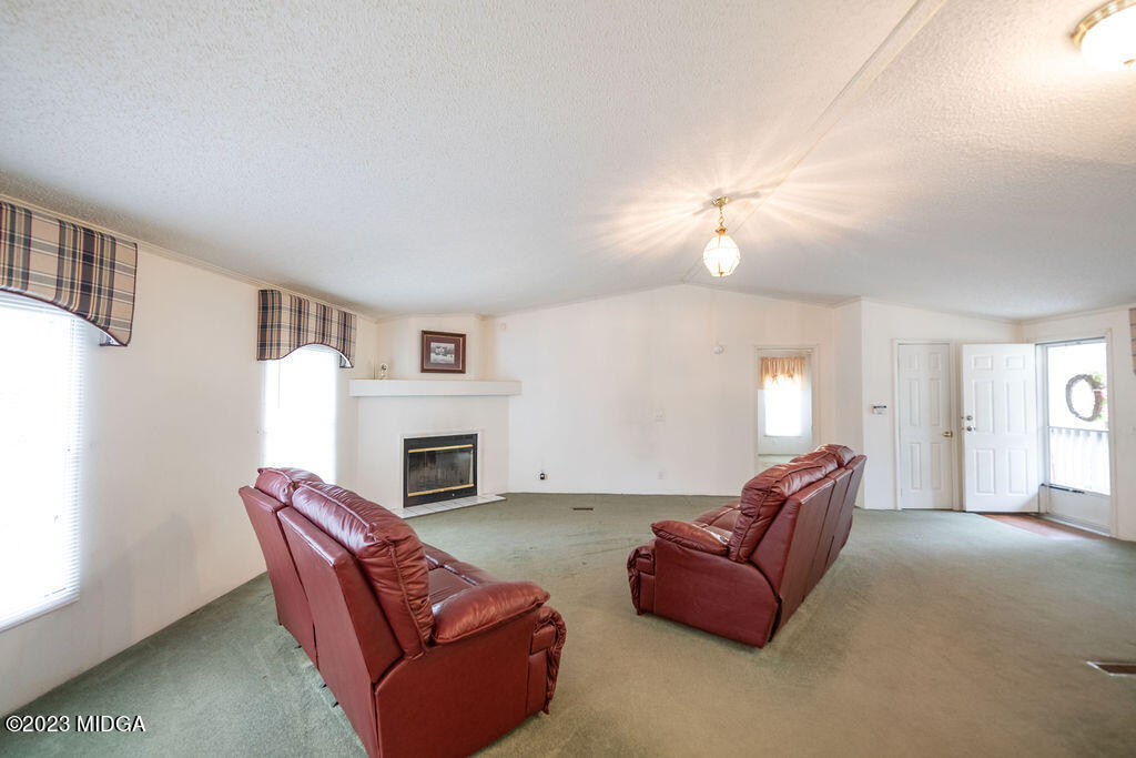 5933 Moseley Dixon Road Macon, GA 31220 - Photo 9 of 38 a living room with furniture a fireplace and a window