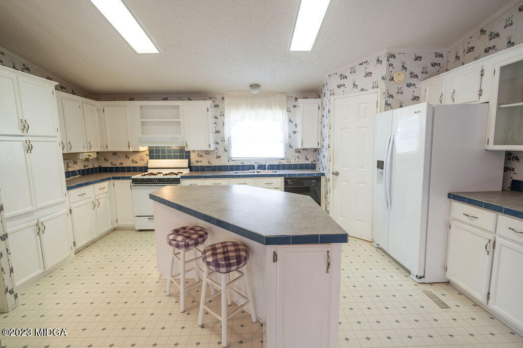 5933 Moseley Dixon Road Macon, GA 31220 - Photo 10 of 38 a kitchen with stainless steel appliances granite countertop a sink stove and refrigerator