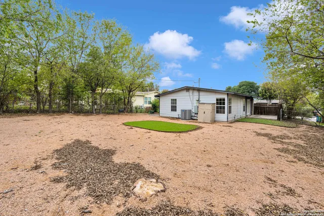 a view of a house with backyard and tree