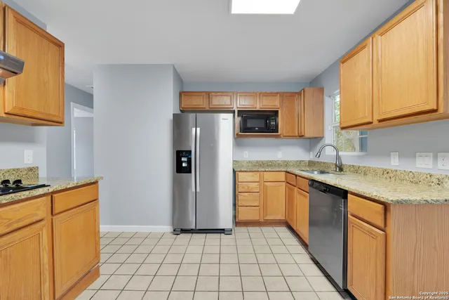 a kitchen with stainless steel appliances granite countertop a refrigerator sink and cabinets