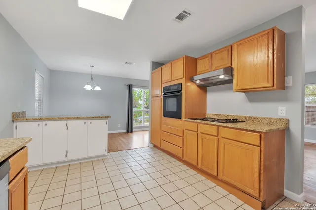 a kitchen with cabinets and wooden floor