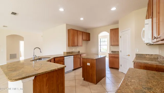 a kitchen with granite countertop a sink and cabinets