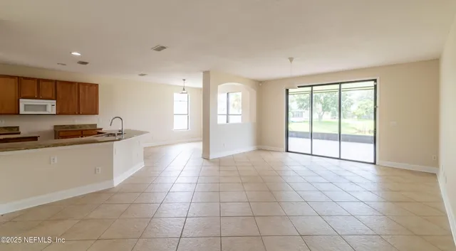 a large white kitchen with a sink and a large window