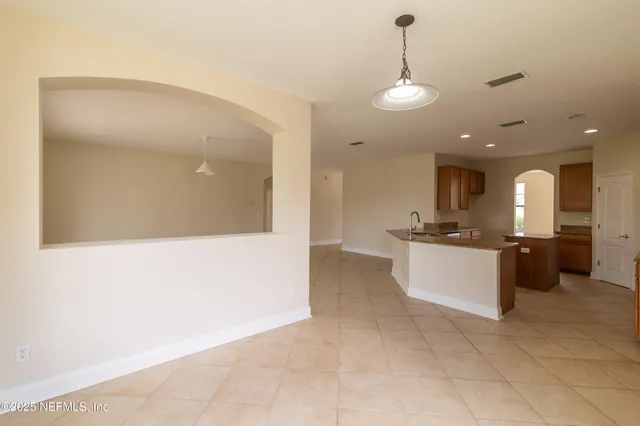 a large kitchen with kitchen island a sink a counter top and stainless steel appliances