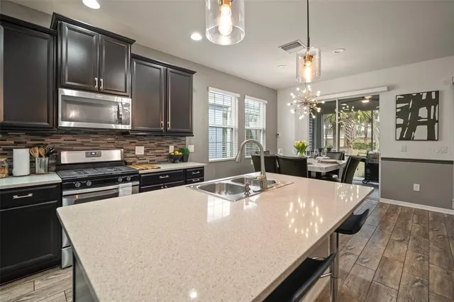 a kitchen with kitchen island a sink stove and refrigerator