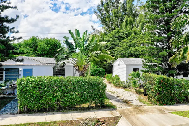 a view of a house with a yard and large tree