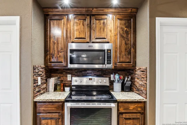 a kitchen with granite countertop a stove and a microwave