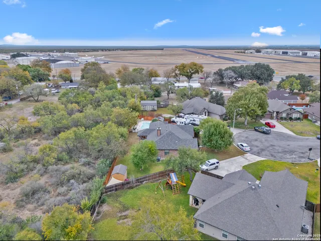 an aerial view of a house with a yard and lake view