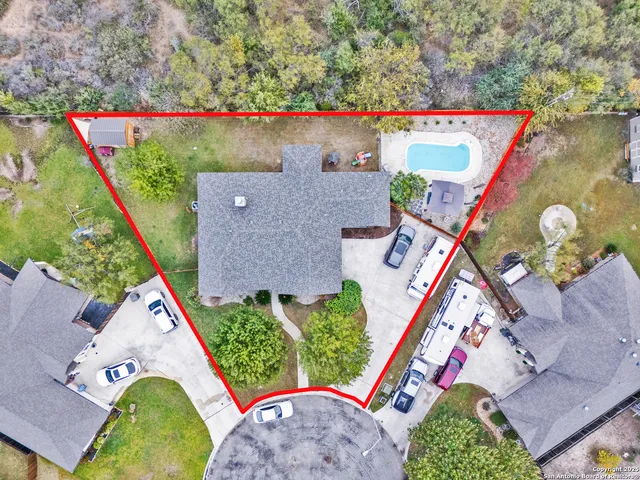 an aerial view of a house with a yard and a large tree