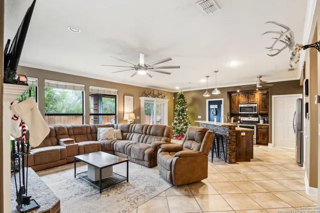 a living room with furniture a flat screen tv and a floor to ceiling window