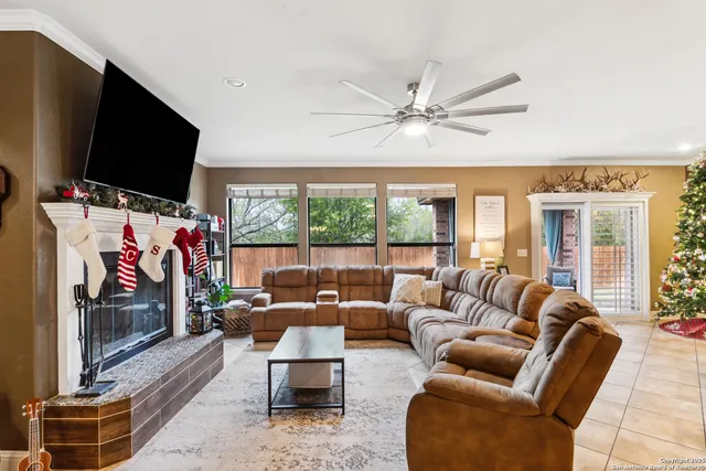 a living room with furniture a flat screen tv and a floor to ceiling window