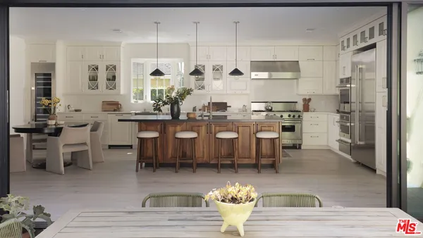 a kitchen with appliances cabinets and chair