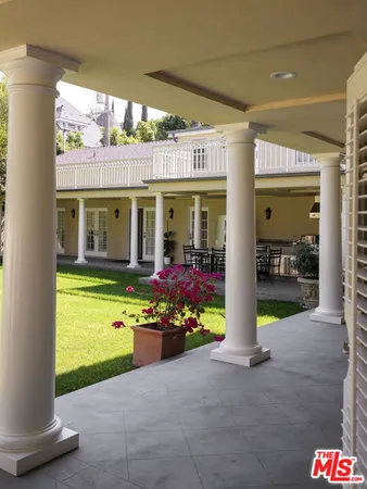 a front view of a house with a porch and garden