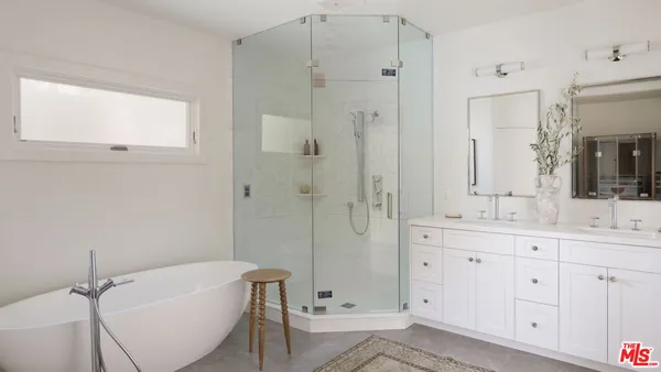 a bathroom with a tub sink and mirror