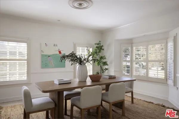 a dining room with furniture potted plants and wooden floor