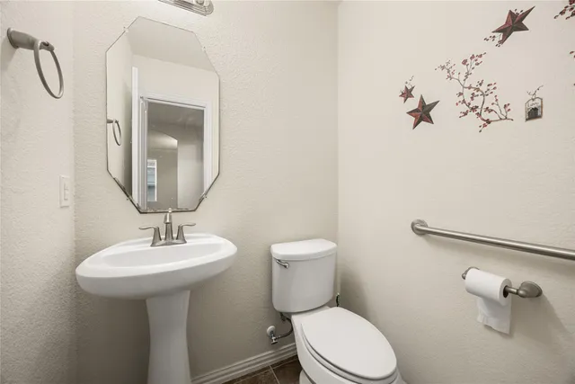 a bathroom with a toilet sink and mirror