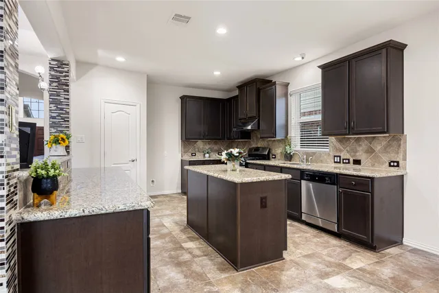 a kitchen with stainless steel appliances granite countertop a sink stove and refrigerator