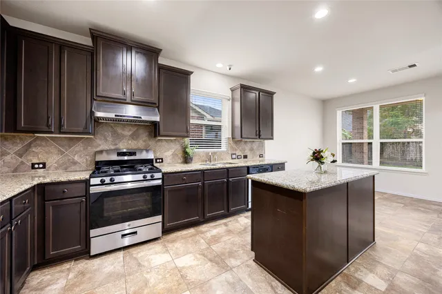 a kitchen with stainless steel appliances granite countertop a sink stove and oven