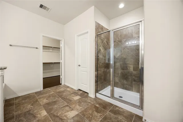 a bathroom with a shower and a glass door