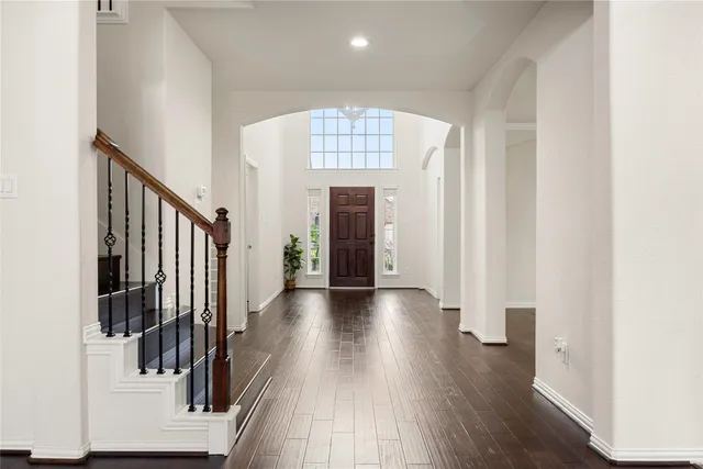 a view of a hallway with wooden floor and staircase