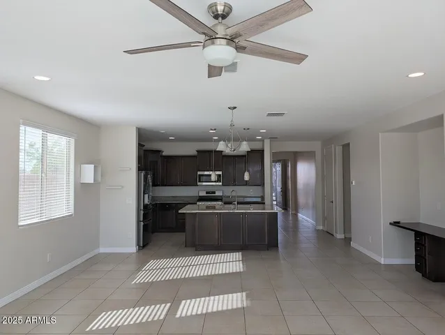 a kitchen with stainless steel appliances kitchen island granite countertop a refrigerator and a stove top oven
