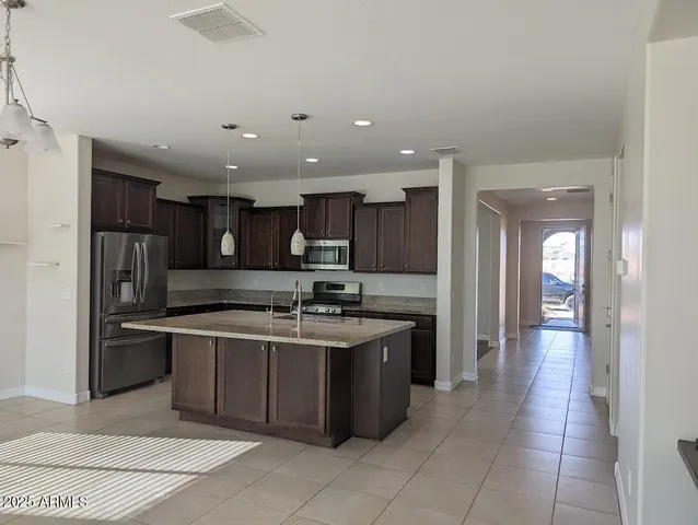 a kitchen with stainless steel appliances granite countertop a sink and a refrigerator