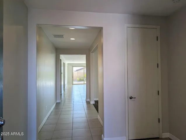 a view of a hallway with closet and a bathroom