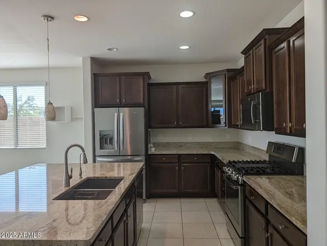 a kitchen with granite countertop a stove and a sink